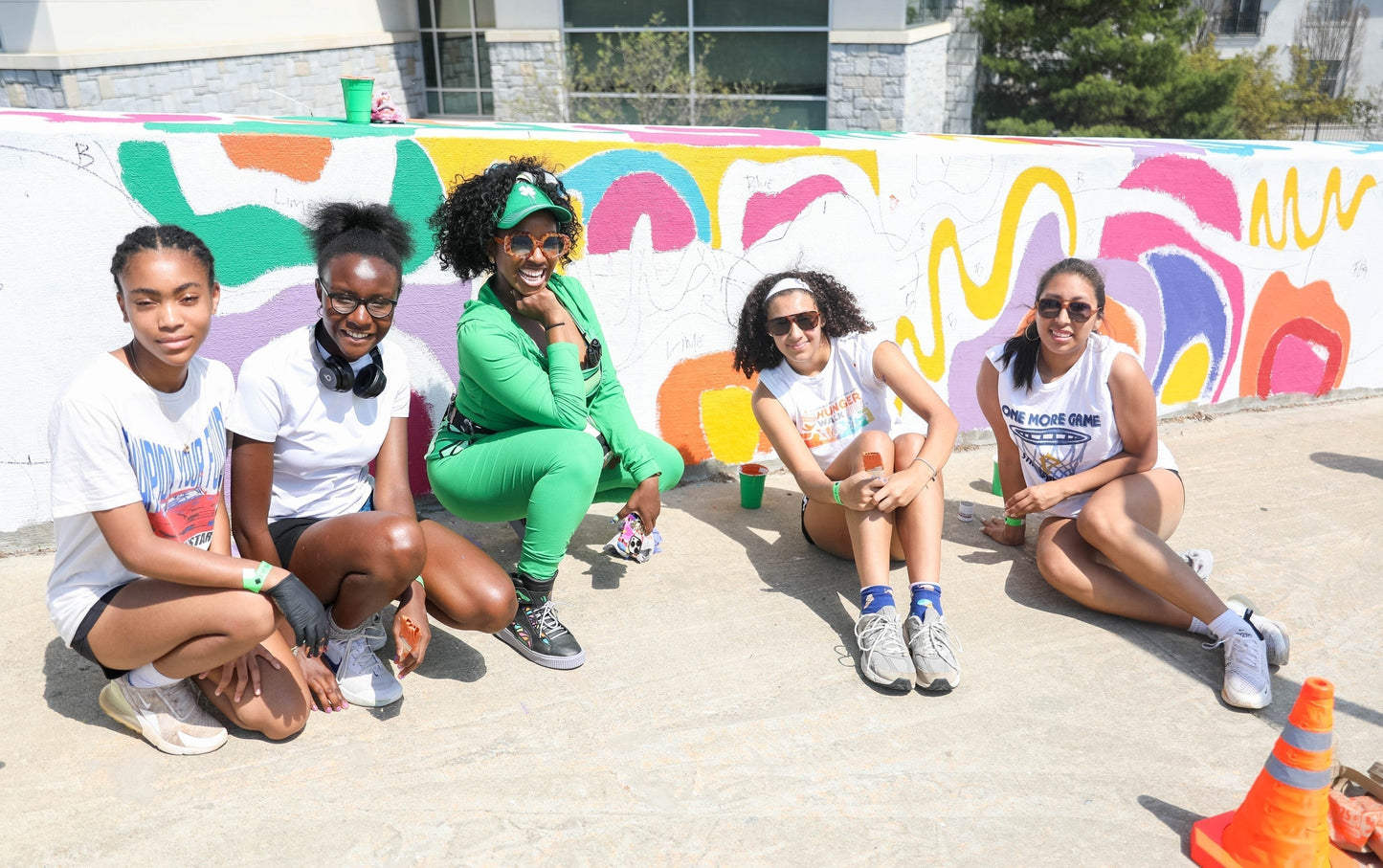 Melissa Mitchell painting her FIFA 2026 mural alongside the Girl Scouts of Greater Atlanta on the 17th Street Bridge near Atlantic Station, a public art project commissioned by the City of Atlanta.