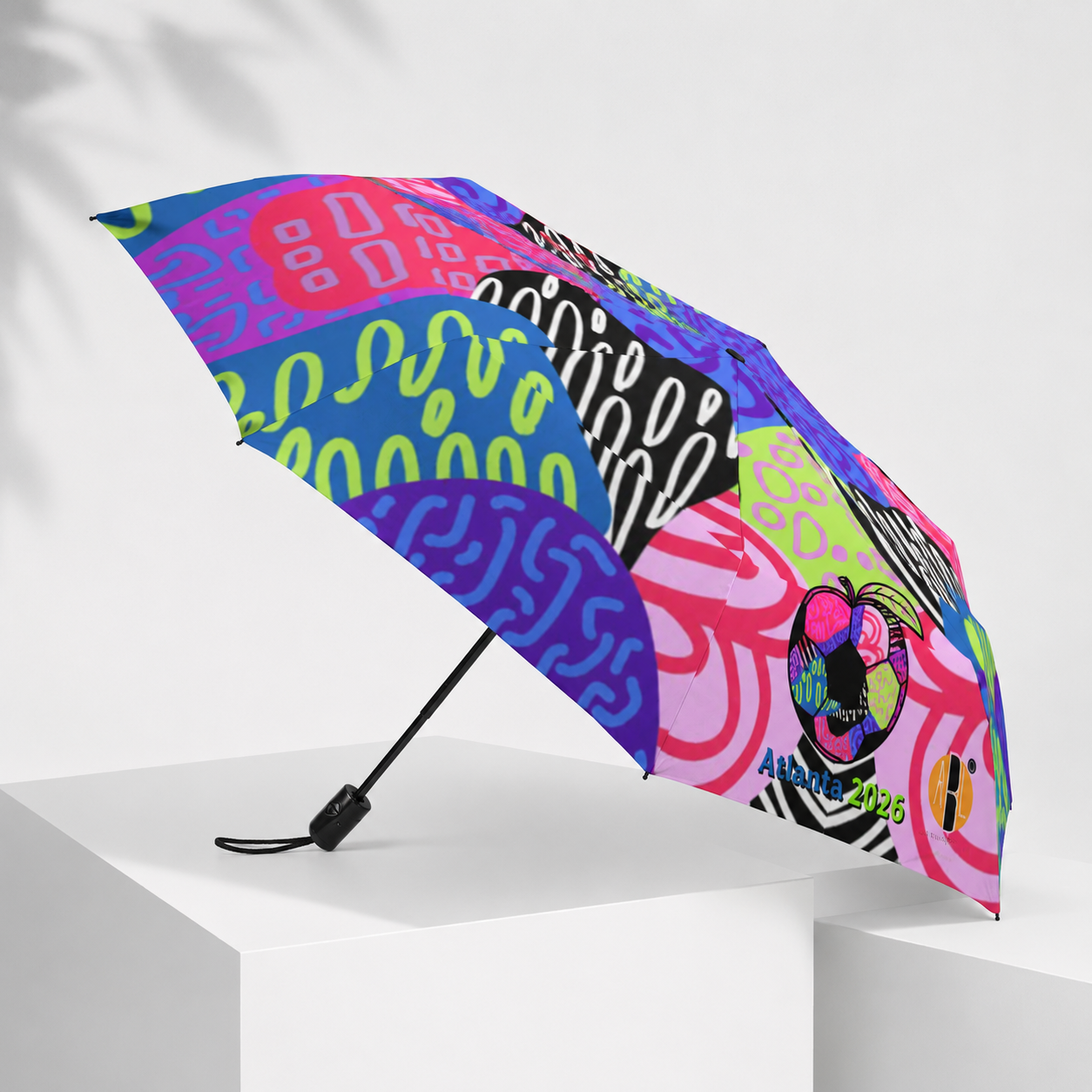 Colorful Ponce Pop compact umbrella featuring bold abstract artwork inspired by Atlanta culture, wearable art, FIFA energy, and vibrant street-style fashion by artist Melissa A. Mitchell.